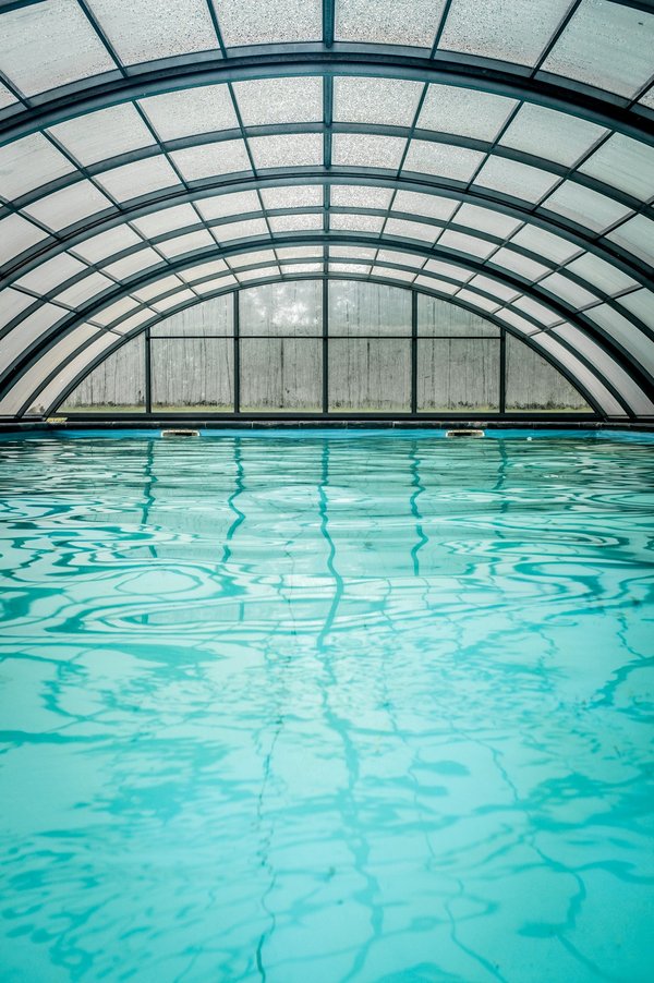 What are the health and safety benefits of a pool enclosure in the UK?